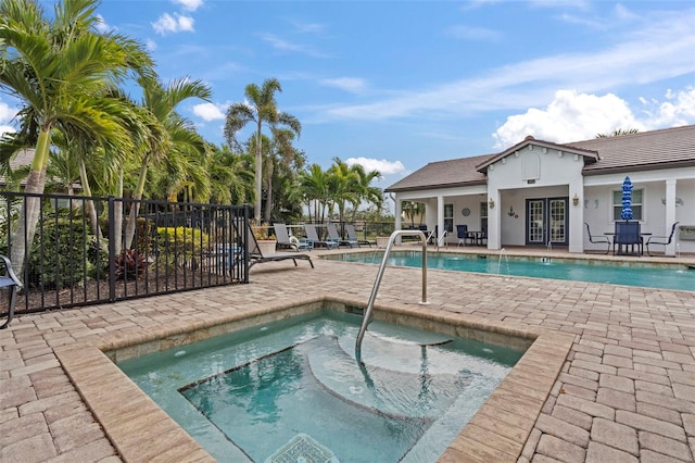 view of pool featuring french doors, a patio, and a hot tub