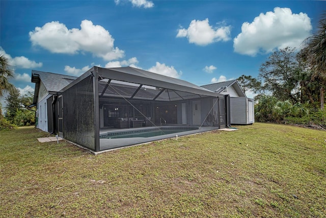 rear view of property featuring glass enclosure and a yard