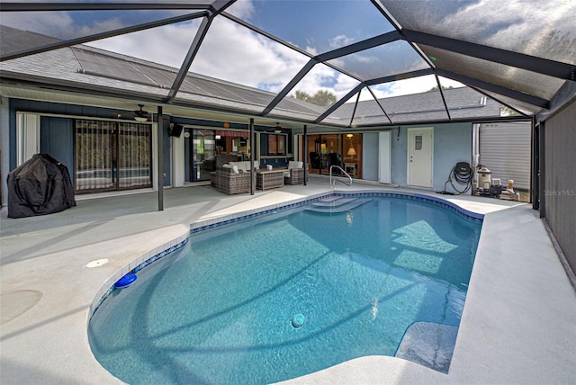 view of pool featuring glass enclosure, ceiling fan, a patio, and an outdoor hangout area