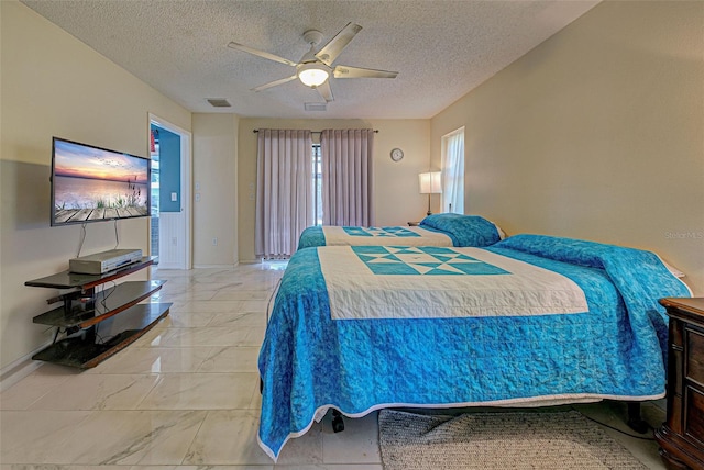 bedroom featuring ceiling fan and a textured ceiling