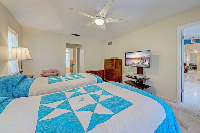 bedroom with ceiling fan and a textured ceiling