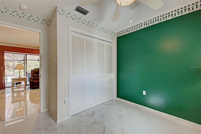 bedroom with a textured ceiling, a closet, and ceiling fan