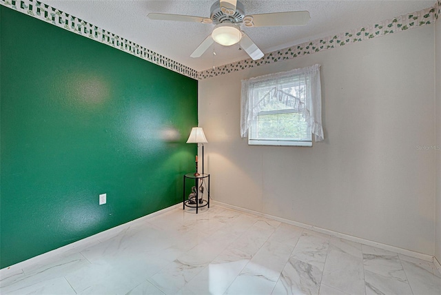 empty room featuring ceiling fan and a textured ceiling