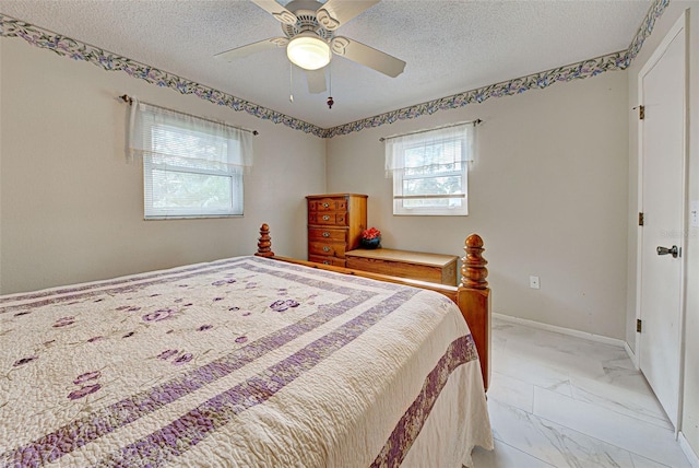 bedroom with ceiling fan and a textured ceiling