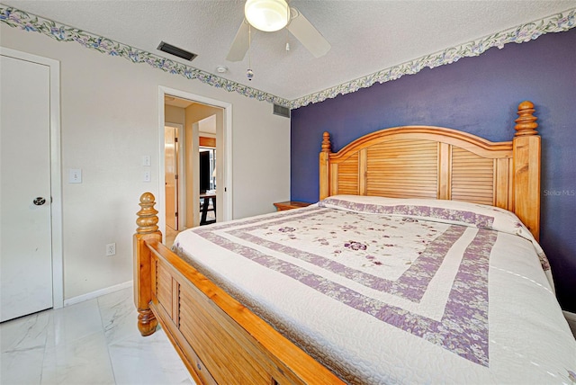 bedroom with ceiling fan and a textured ceiling