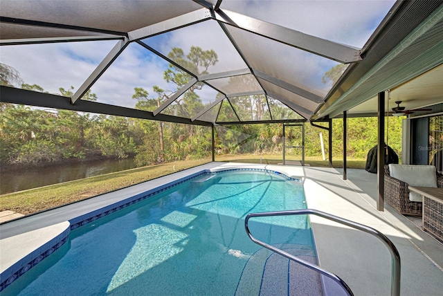 view of swimming pool with a patio, a water view, and glass enclosure