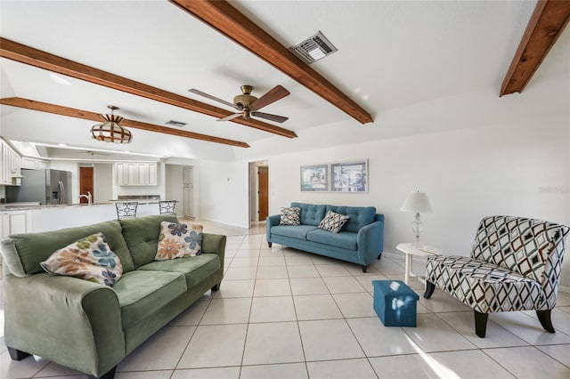 tiled living room featuring ceiling fan, sink, and beamed ceiling