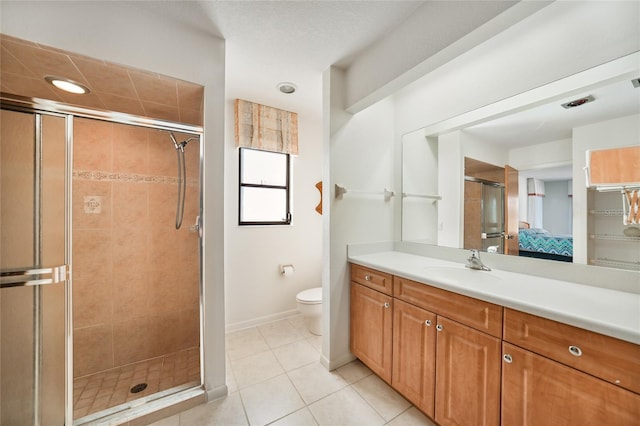 bathroom featuring tile patterned flooring, vanity, toilet, and walk in shower