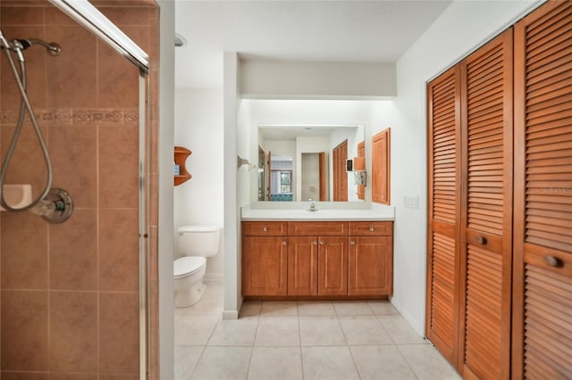 bathroom with tile patterned floors, vanity, toilet, and an enclosed shower