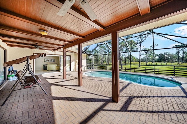 outdoor pool with a ceiling fan, a lanai, a yard, and a patio