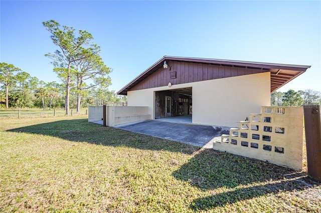 view of home's exterior with an outbuilding and a lawn