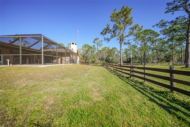 view of yard with glass enclosure and fence