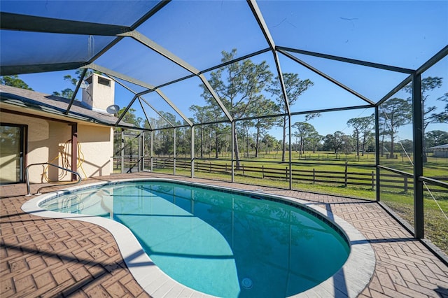 pool with glass enclosure, a patio, and a lawn