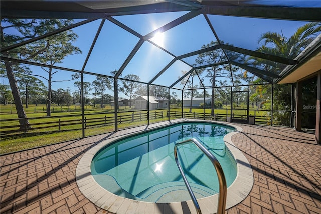 outdoor pool with a lanai, a patio, and a yard