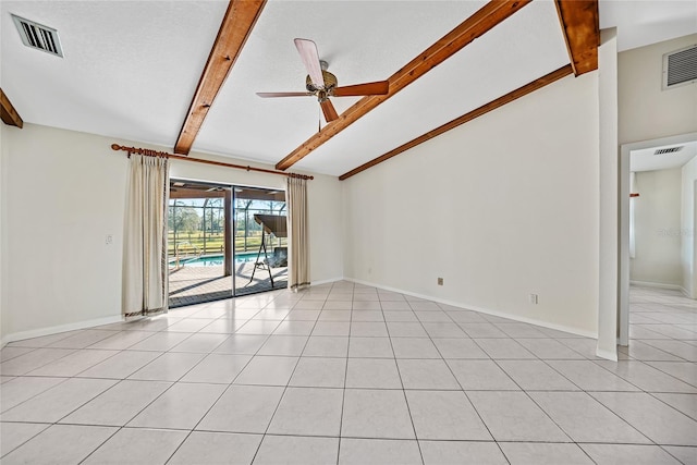 empty room featuring lofted ceiling with beams, light tile patterned floors, visible vents, and a ceiling fan