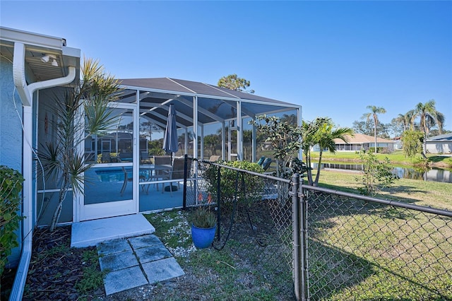 view of dock featuring glass enclosure and a yard