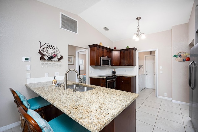 kitchen featuring lofted ceiling, decorative light fixtures, kitchen peninsula, sink, and appliances with stainless steel finishes