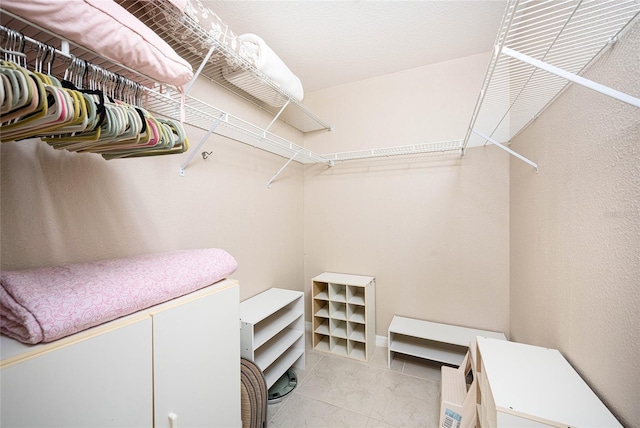 spacious closet with light tile patterned floors