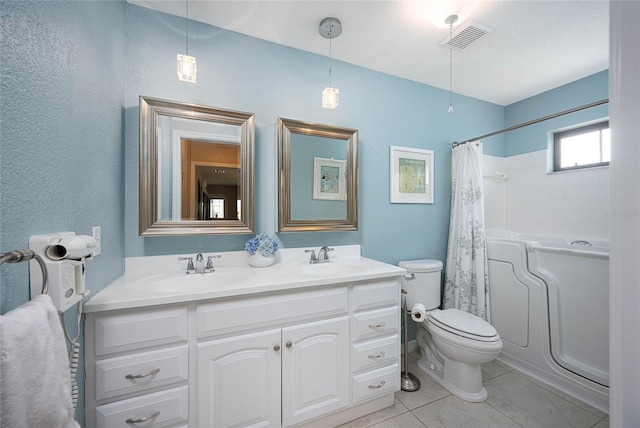 full bathroom with a textured ceiling, tile patterned flooring, vanity, shower / bath combination with curtain, and toilet