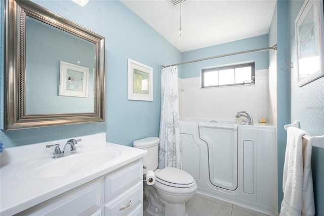 bathroom featuring toilet, tile patterned flooring, a tub, a textured ceiling, and vanity