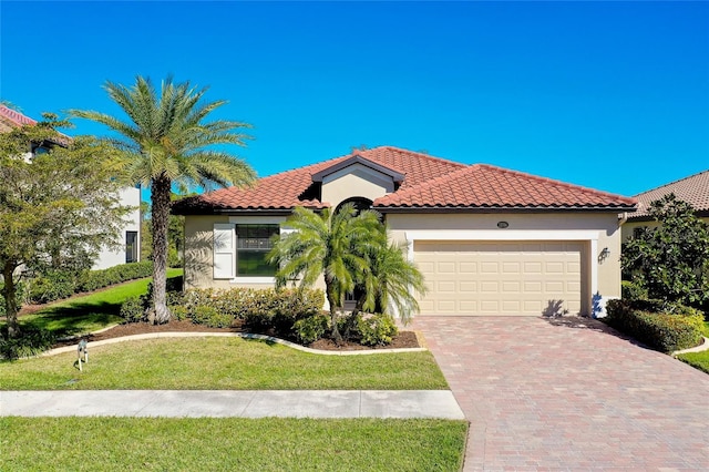 mediterranean / spanish-style home featuring a front yard and a garage