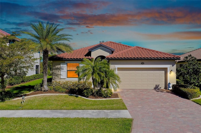 mediterranean / spanish house with a yard and a garage