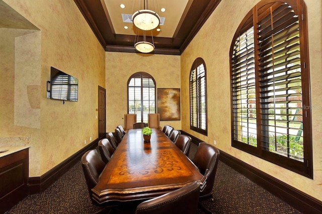 dining room with a notable chandelier, crown molding, and a high ceiling