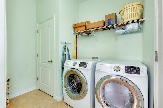 clothes washing area with independent washer and dryer and light tile patterned floors