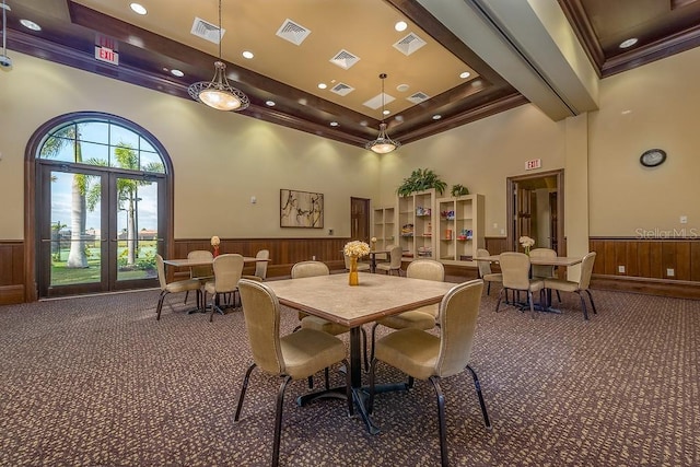 dining area with french doors, a tray ceiling, crown molding, a high ceiling, and carpet floors