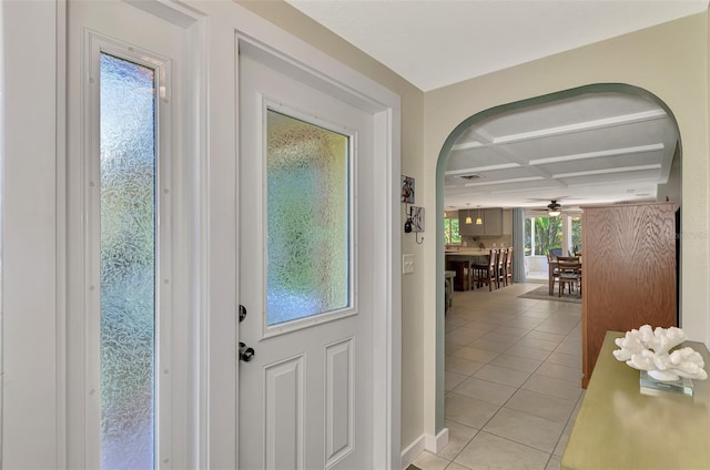 doorway to outside featuring beamed ceiling, ceiling fan, light tile patterned floors, and coffered ceiling