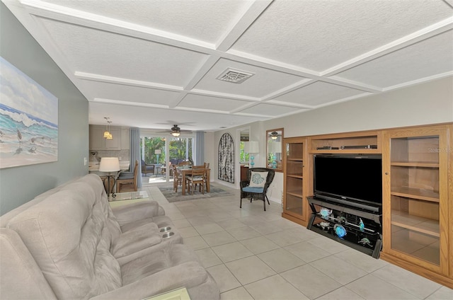 living room featuring a textured ceiling, ceiling fan, light tile patterned floors, and coffered ceiling