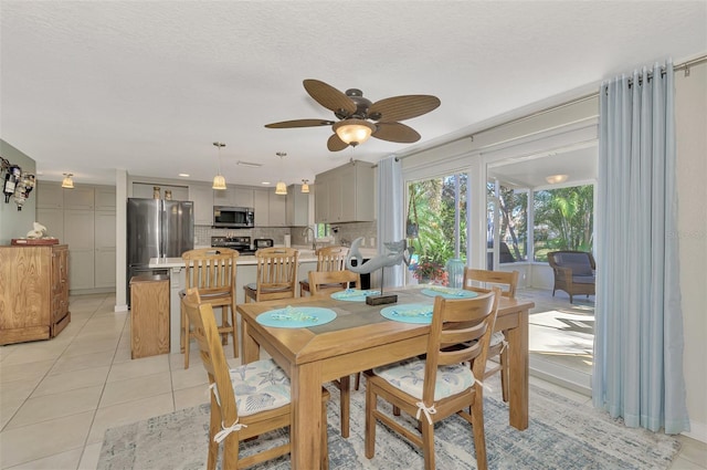 dining room with ceiling fan, sink, light tile patterned floors, and a textured ceiling