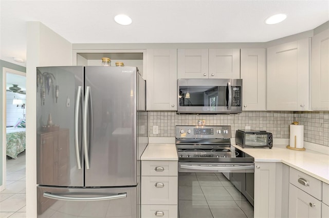 kitchen featuring decorative backsplash, light tile patterned floors, and stainless steel appliances