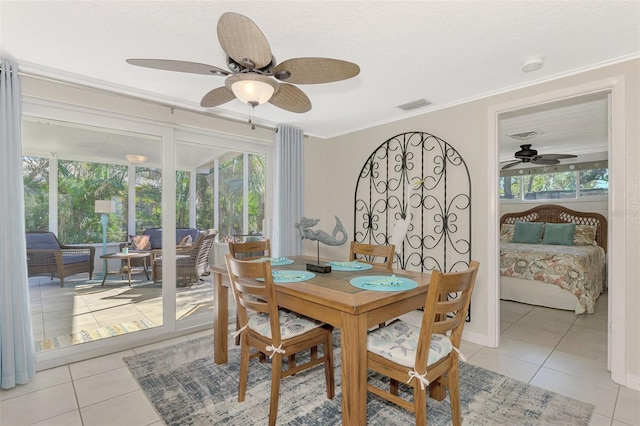 dining room with ceiling fan, light tile patterned floors, and crown molding