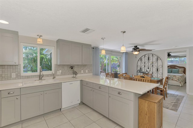 kitchen featuring kitchen peninsula, gray cabinets, dishwasher, and sink