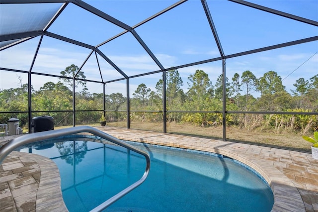 view of pool with glass enclosure and a patio