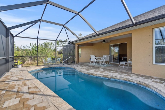 view of pool with ceiling fan, a lanai, and a patio area