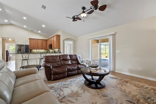 living room featuring ceiling fan, light tile patterned floors, and lofted ceiling