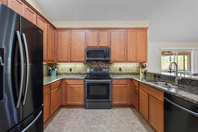 kitchen featuring sink, light tile patterned flooring, dark stone countertops, black appliances, and decorative backsplash