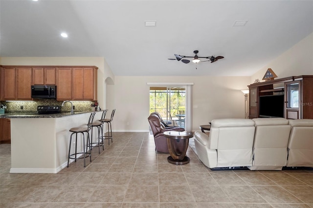 living room with sink, ceiling fan, and light tile patterned floors