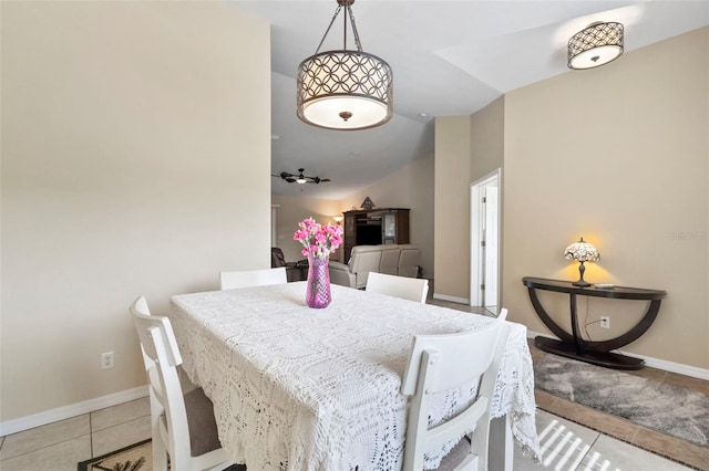 dining area with light tile patterned floors and vaulted ceiling