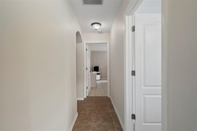 corridor with dark tile patterned flooring