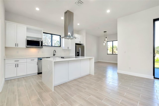 kitchen with island exhaust hood, white cabinets, a kitchen island, and stainless steel appliances