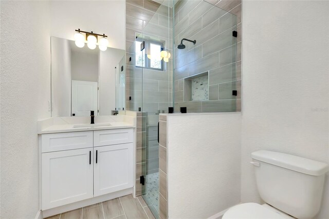 bathroom featuring vanity, toilet, and walk in shower