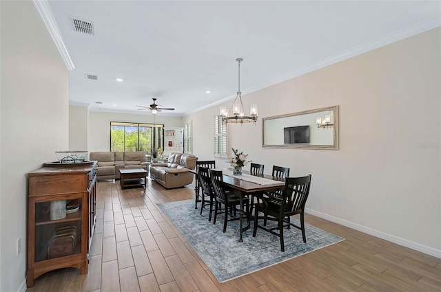 dining area with ceiling fan with notable chandelier and crown molding