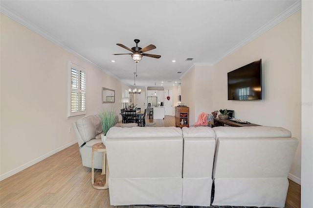 living room featuring ornamental molding, ceiling fan with notable chandelier, and light hardwood / wood-style flooring