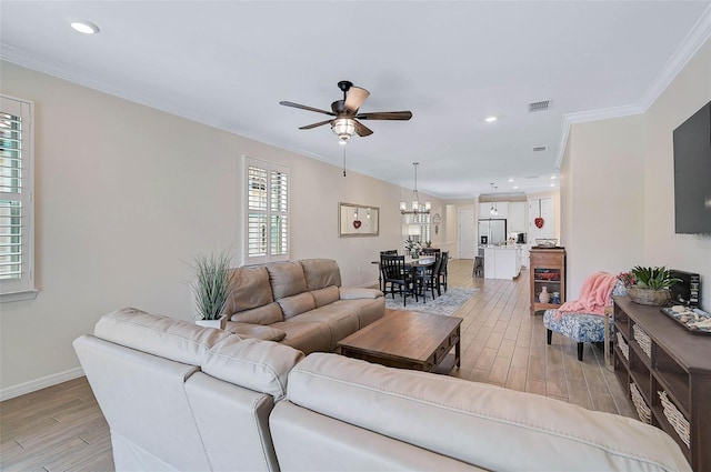 living room featuring crown molding and ceiling fan with notable chandelier