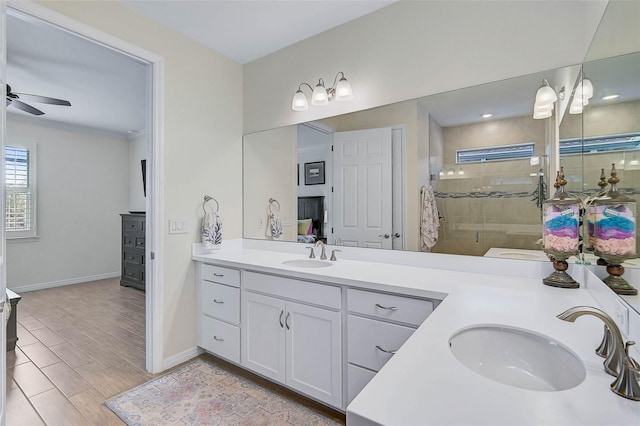 bathroom with ceiling fan, vanity, and a tile shower