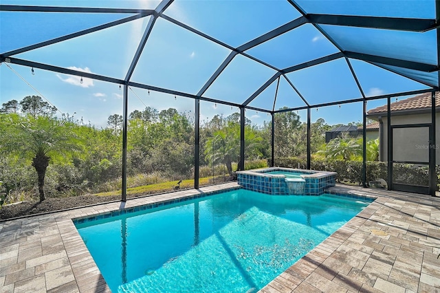 view of swimming pool with glass enclosure, an in ground hot tub, and a patio area