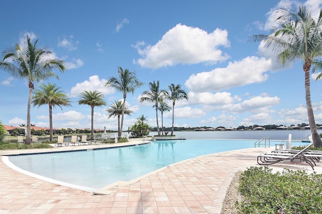 view of pool featuring a patio area and a water view